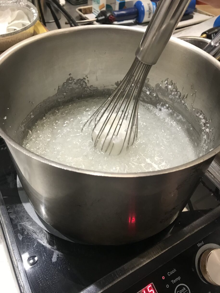 A large pot of boiling isomalt with a whisk