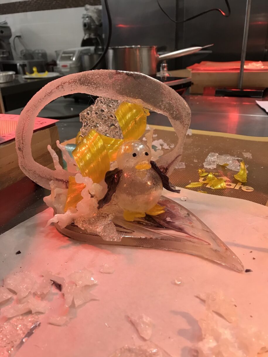 Sugar sculpture with blown sugar penguin and yellow ribbon