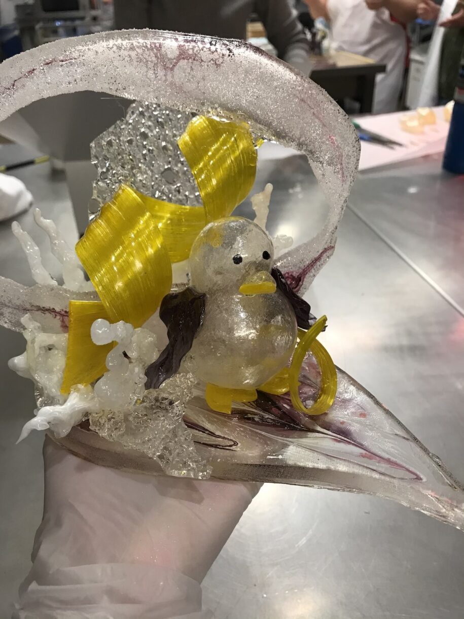 Sugar sculpture with blown sugar penguin and yellow ribbon