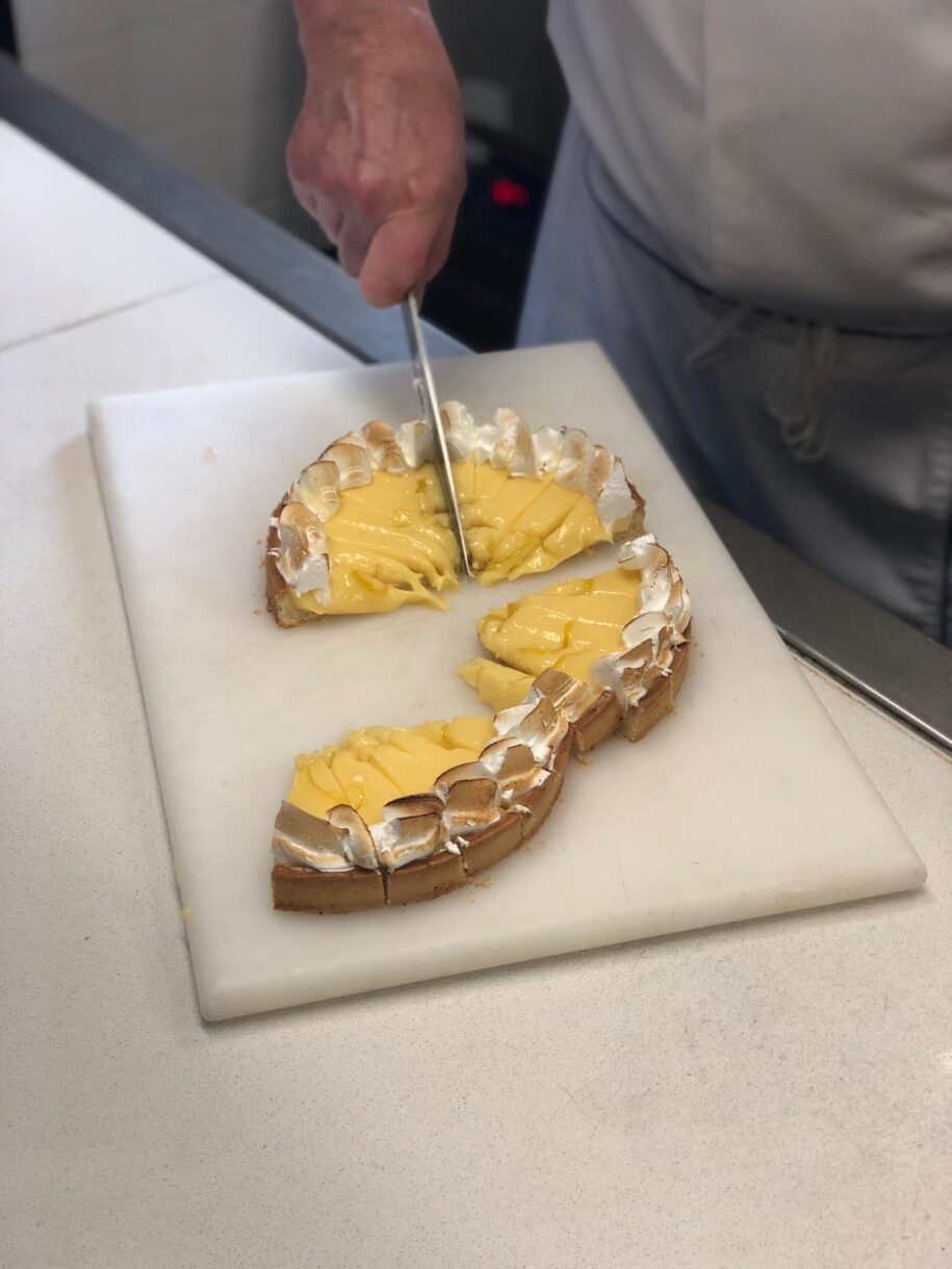 Tarte aux citrons being cut into slices for tasting