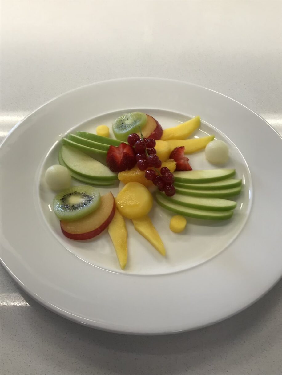 Fruit plate with apples, kiwi, melon, mango, and redcurrant