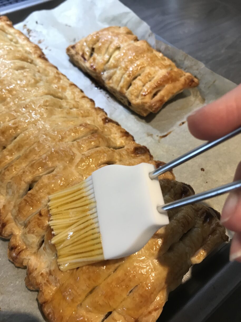 Pastry brush brushing jalousie with mincemeat and apples