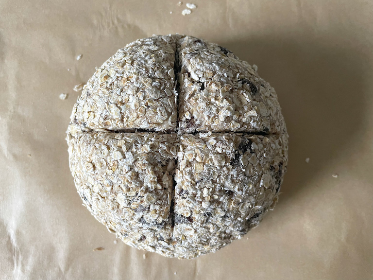 Ball of soda bread dough with an x cut into the top