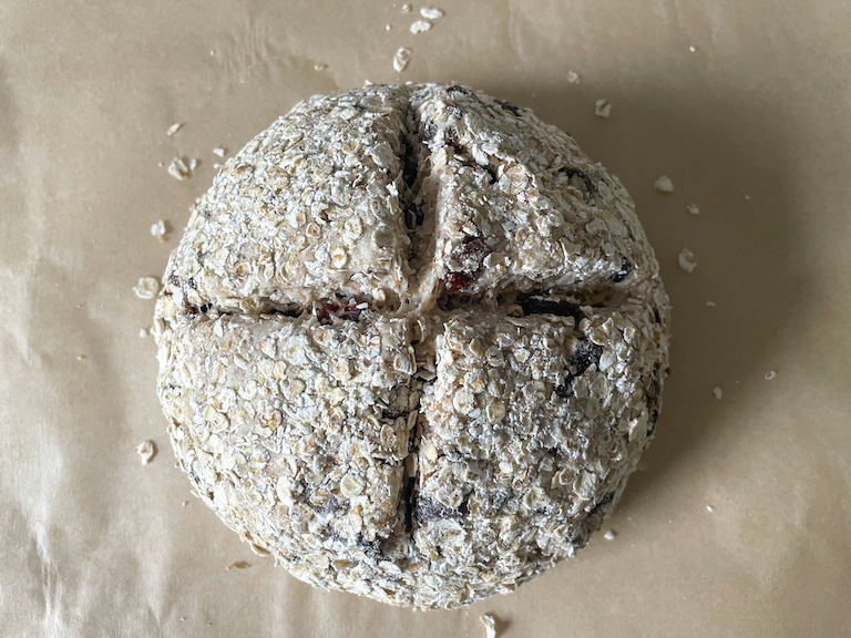 Ball of soda bread dough with an x cut into the top