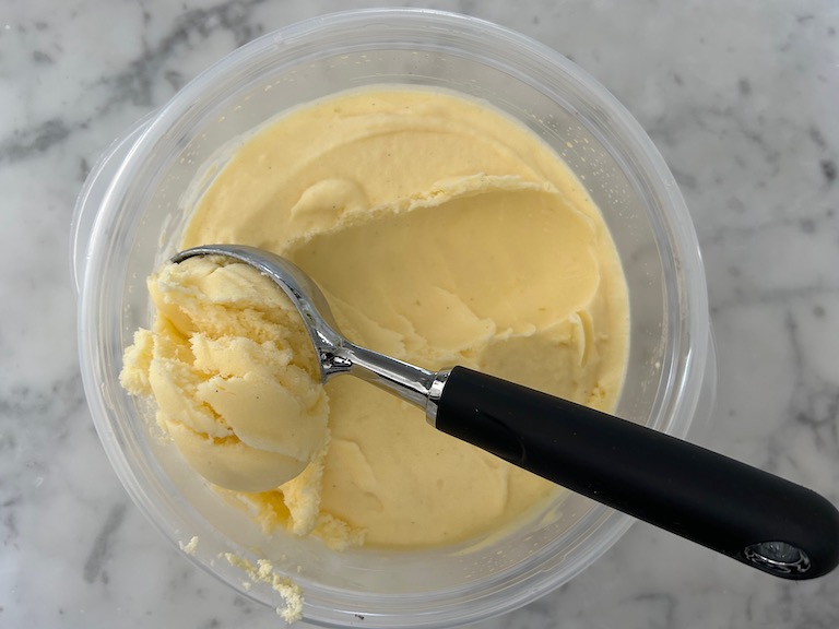 scoop of mango ice cream and an ice cream scoop