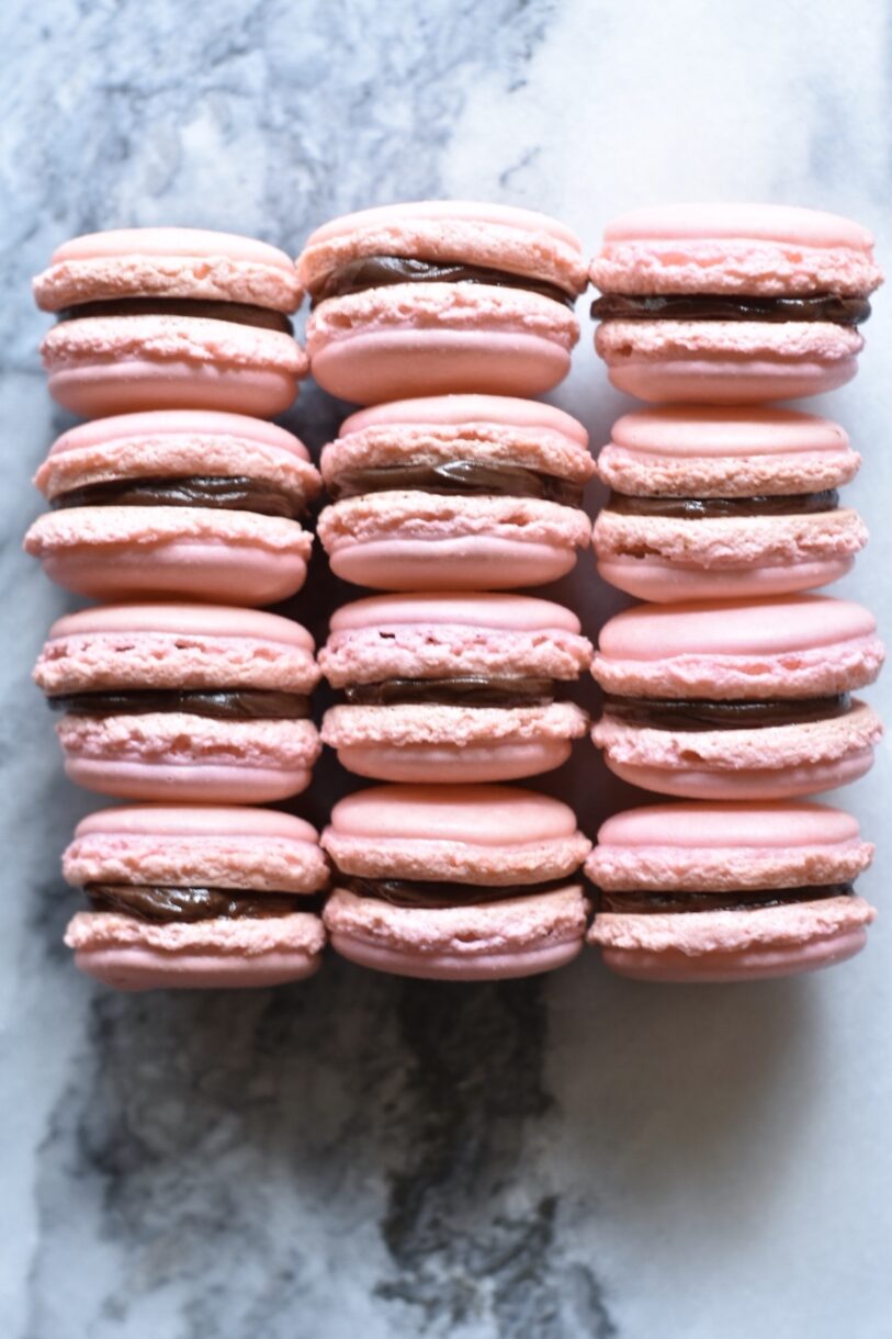 Pink macarons arranged on a marble background