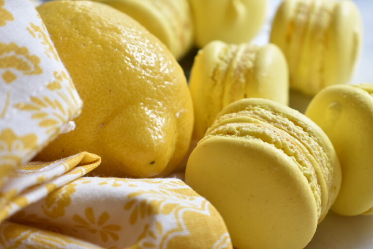 Lemon macarons with a yellow tea towel and fresh lemon
