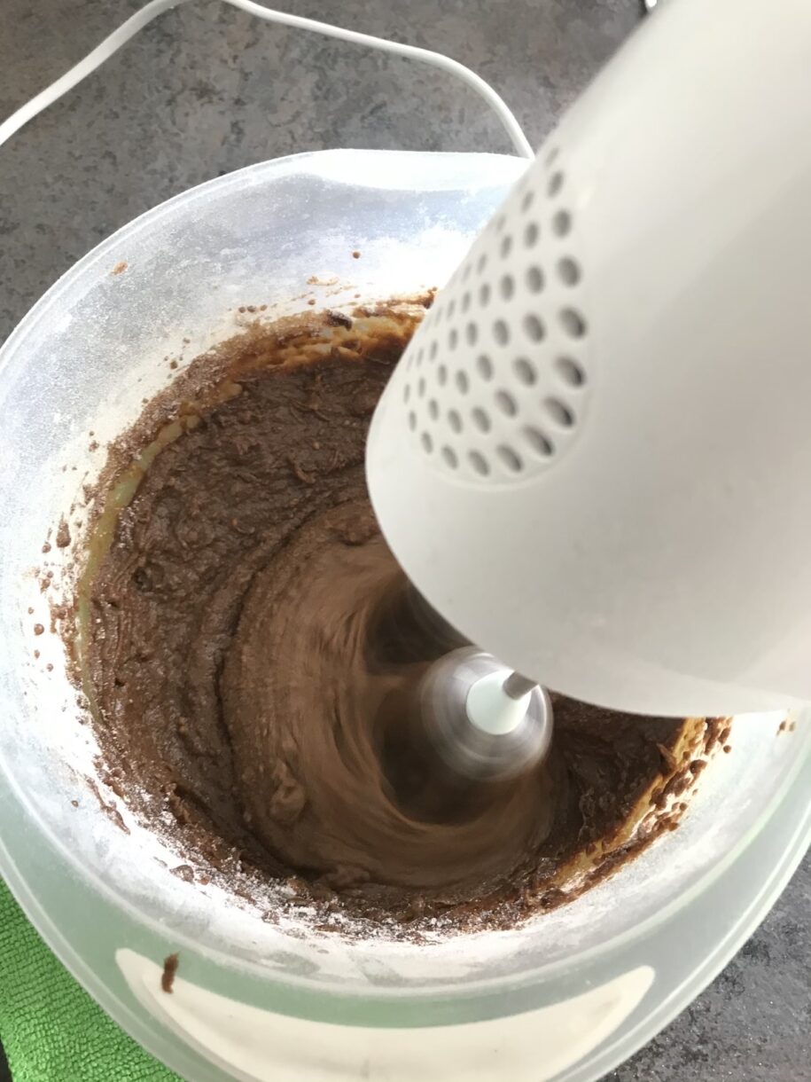 A mixing bowl and mixer, mixing gingerbread dough