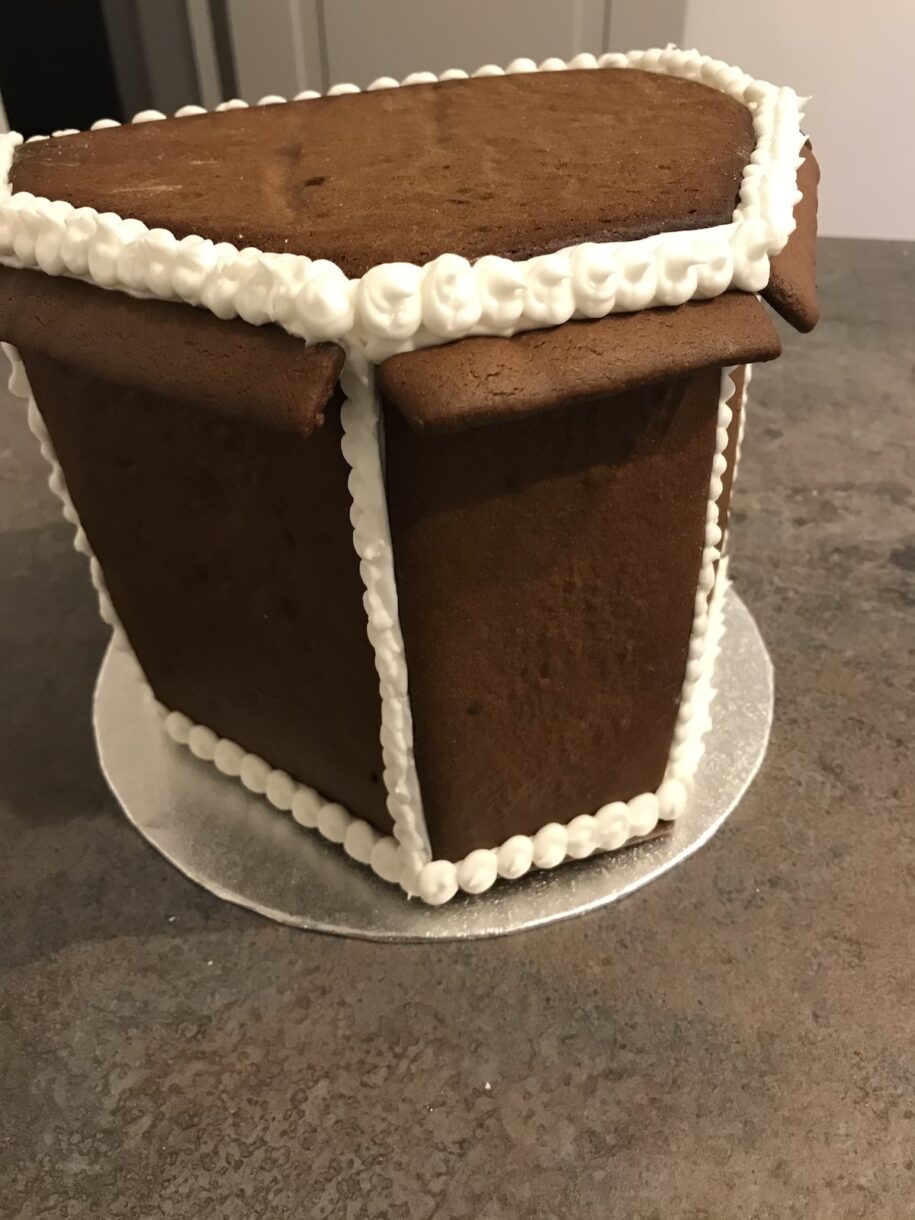 Gingerbread house construction with royal icing piping