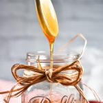 Original food photography of a spoon drizzling honey into a jar