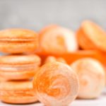 Creamsicle macarons on white background