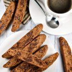 Biscotti slices on white plate with cup of coffee