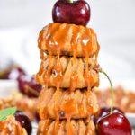 Stack of bundt cakes with caramel drizzle and a cherry on top