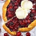 Food photograph looking down at a cherry galette with ice cream