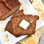 Banana bread with pat of butter on white plate