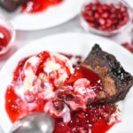 A plate with pie, pomegranate sauce, and ice cream