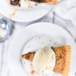 Photograph looking down at a slice of shoo fly pie with ice cream