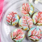 Food photograph of a plate of painted cherry blossom macarons