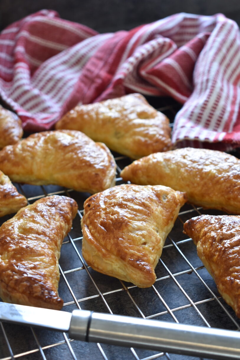apple turnovers and a tea towel on a wire rack
