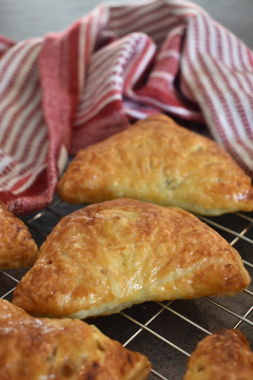 Apple turnovers and red tea towel on a wire rack