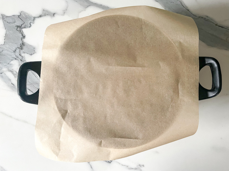 A saucepan with a sheet of parchment on top