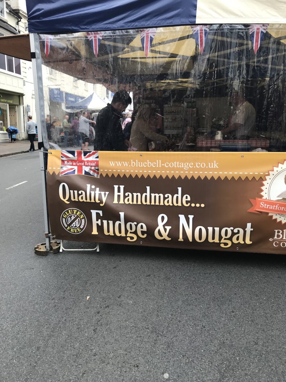 Fudge booth at a street fair in Stratford-Upon-Avon, UK, with a sign advertising quality handmade fudge and nougat