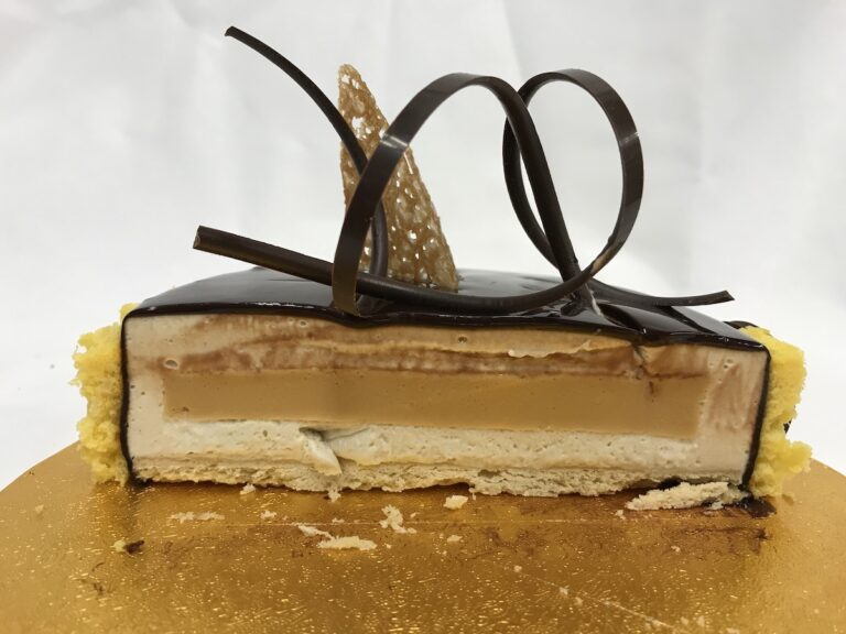 Cross section of the entremet I created for my mock exam, showing mousse, cremeaux and shortbread base