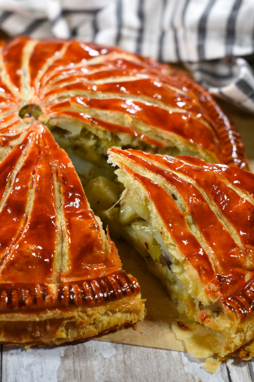 Closeup of slice of pithivier and striped tea towel in background