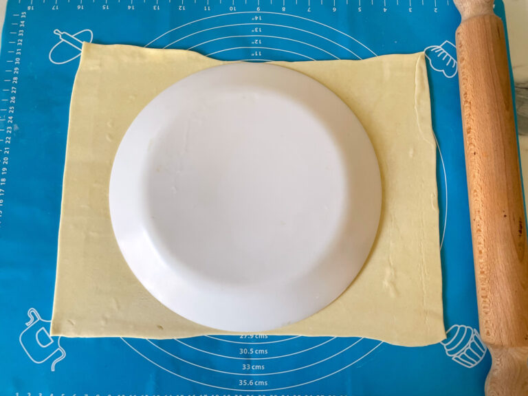 Puff pastry sheet with a dinner plate on top 