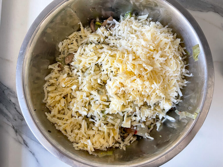 Grated cheese on top of a bowl of vegetables