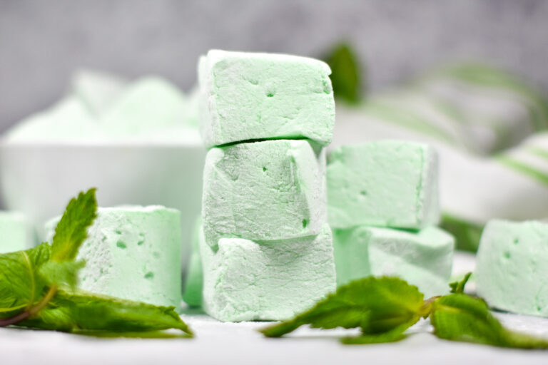 Stack of green mint marshmallows and fresh mint leaves