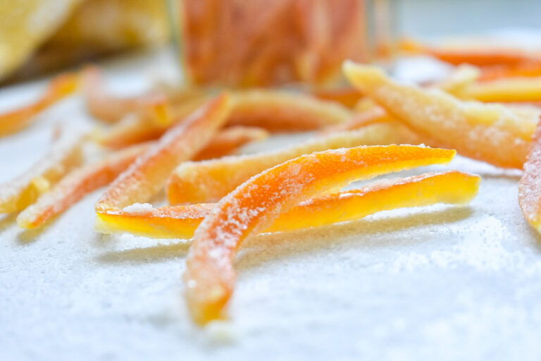 Homemade candied orange peels on white surface