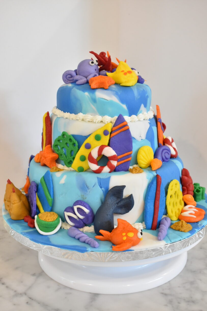 Beach themed cake with three tiers and fondant decorations