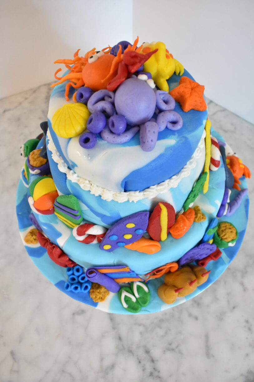 Beach themed cake on a marble countertop