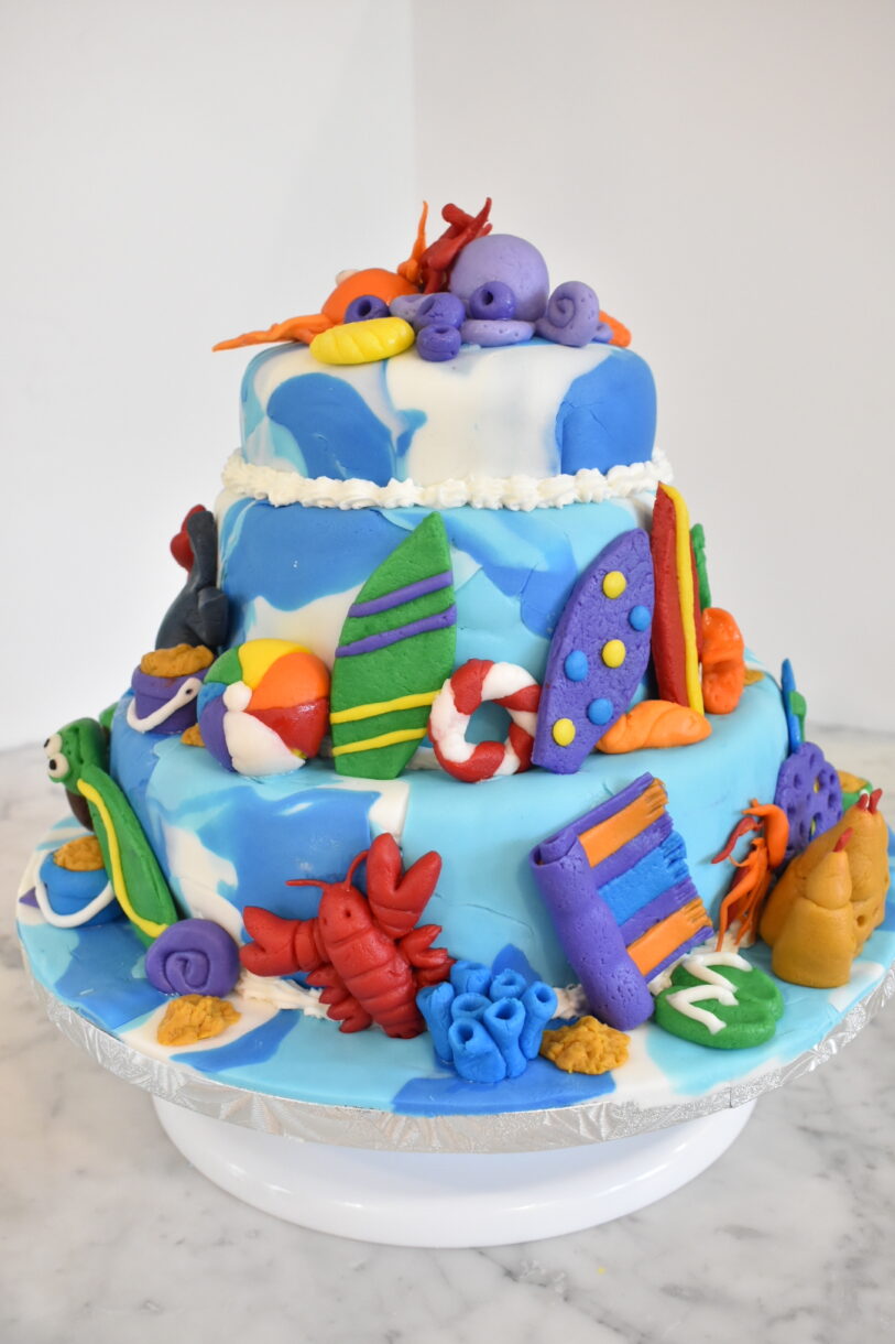 Beach themed cake decorated with rolled and modelled fondant