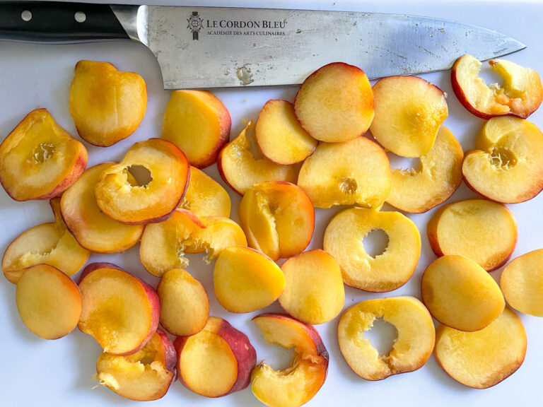 Peach slices on cutting board with knife