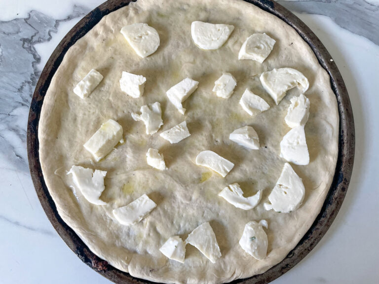 Unbaked pizza crust with mozzarella cheese