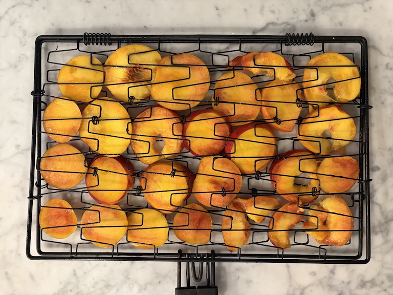 peach slices in a grill basket