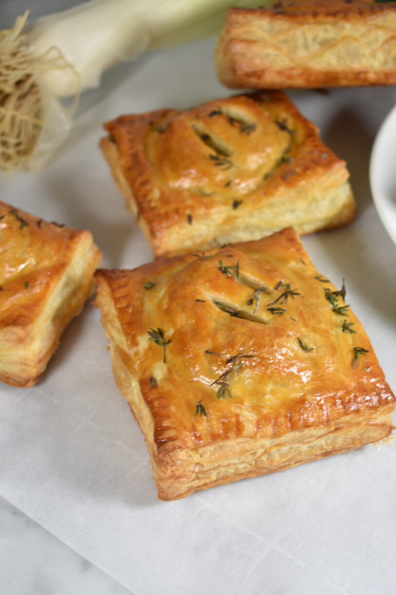 Puff pastry hand pies with bleu cheese and leeks, on a white surface