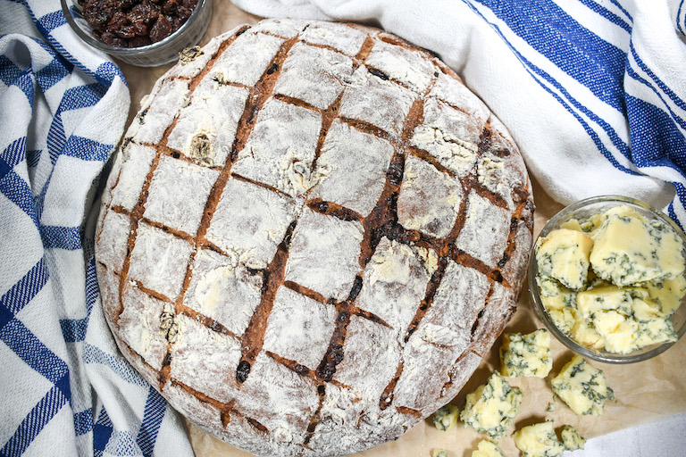 A loaf of blue cheese bread with tea towels and a dish of blue cheese