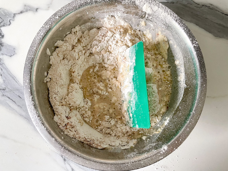 Bread ingredients in a bowl with bench scraper