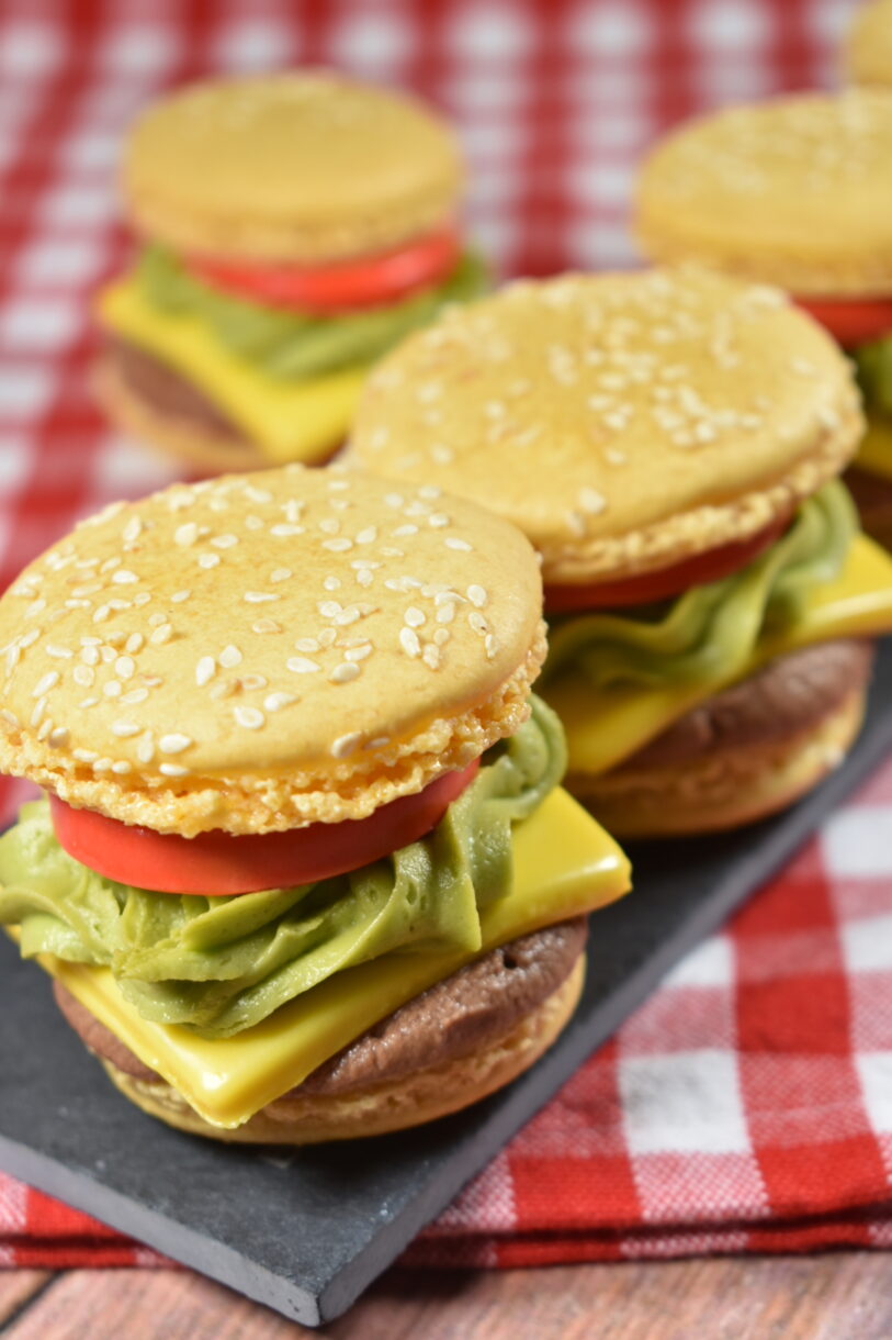 Cheeseburger macarons arranged on a slate board, on a red towel