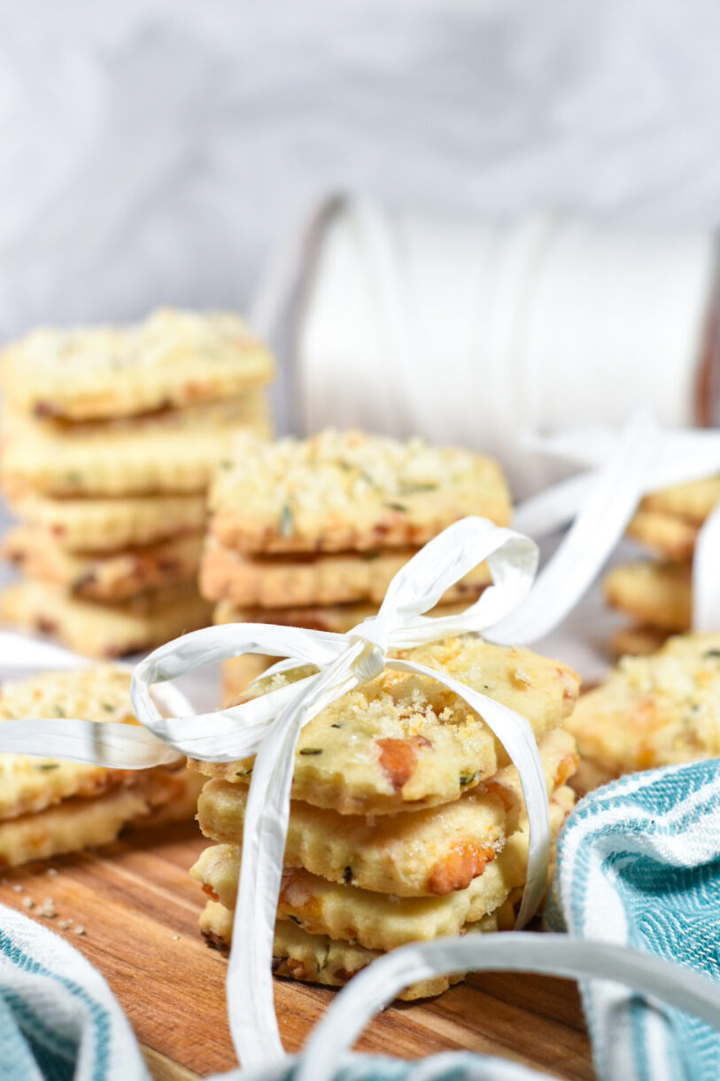 Stacks of rosemary apricot shortbread cookies on a cutting board