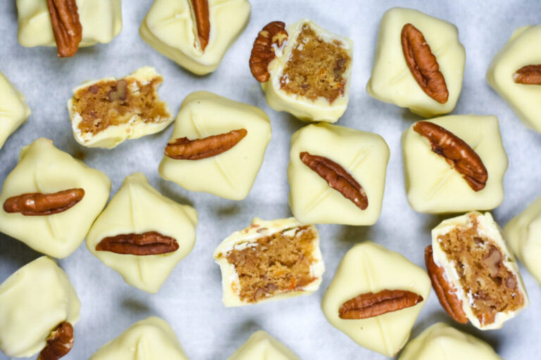 Looking down at white chocolate blondie bites arranged on a white surface