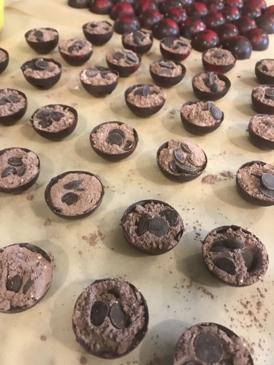 Filling the hot chocolate bombs with cocoa powder and chocolate chips