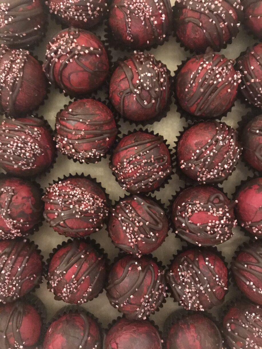 Peppermint hot chocolate bombs in rows on a sheet of parchment