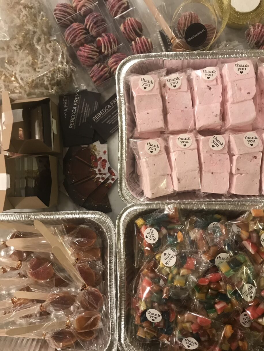 Trays of marshmallows, spoons, candy, and hot chocolate bombs