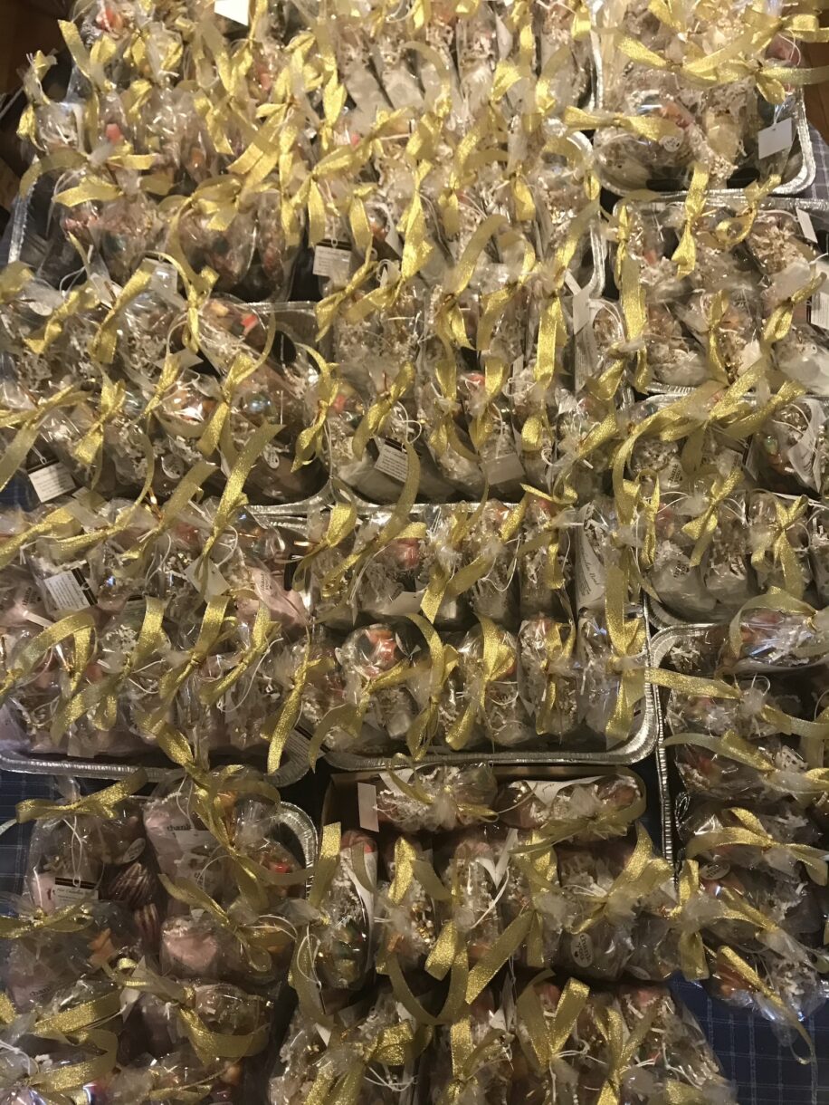 Trays of homemade cocoa bombs in bags, tied with gold ribbons
