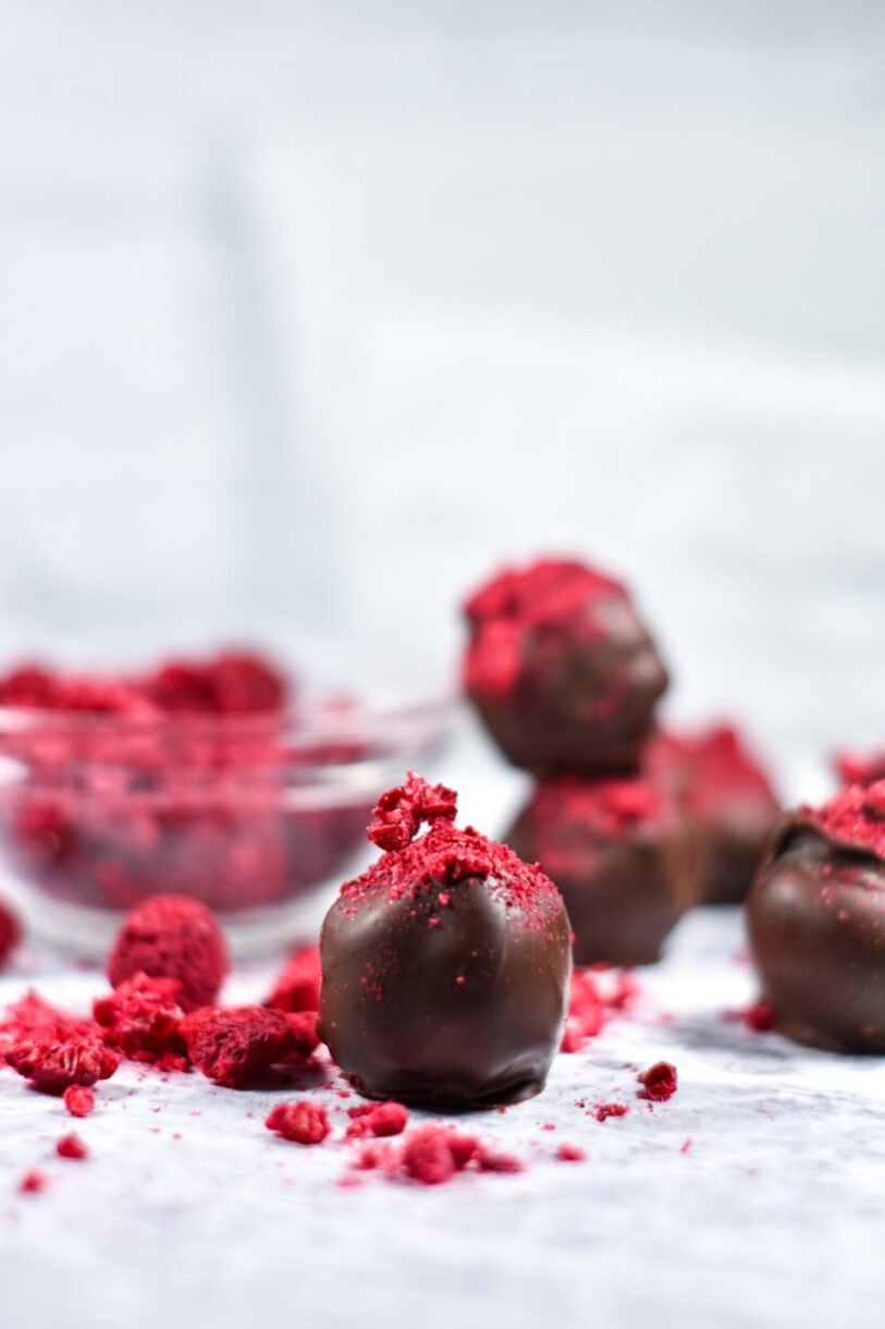 Dark chocolate and raspberry truffles on a white background