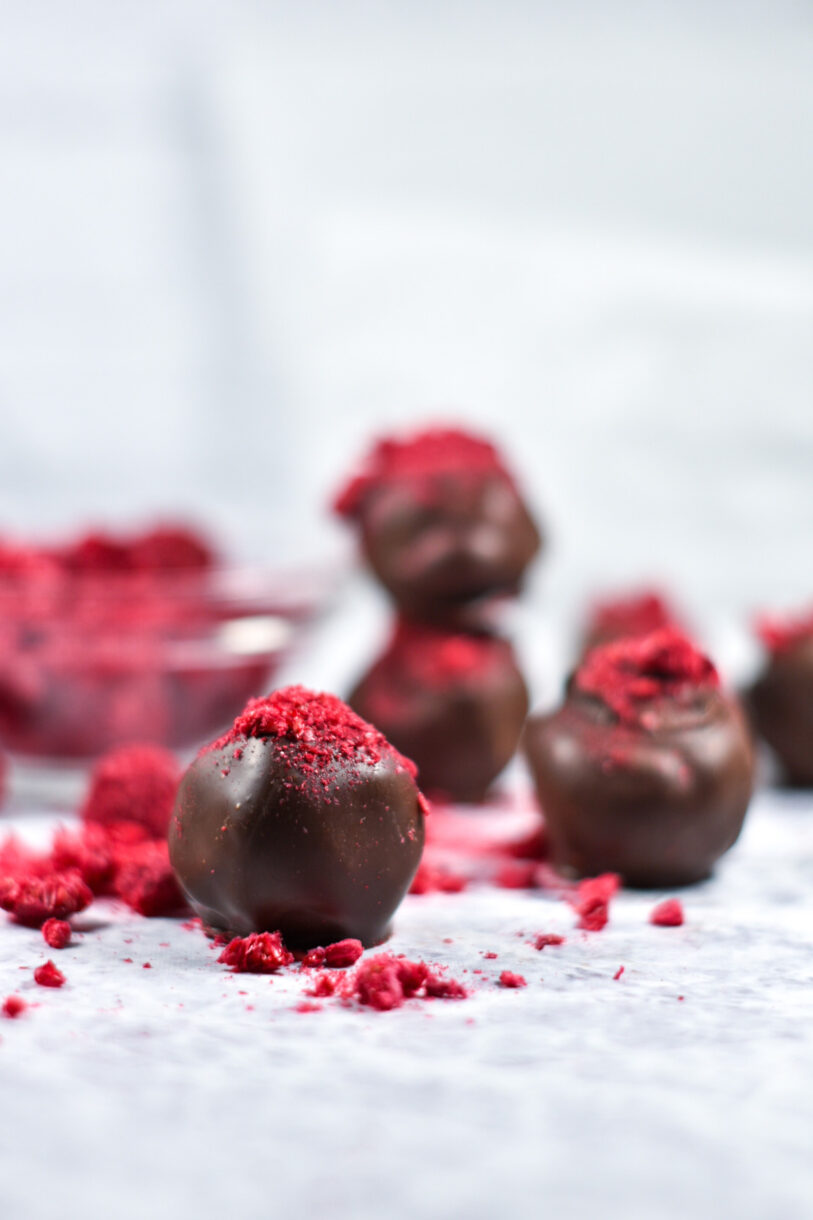 Dark chocolate and raspberry truffles on a white background